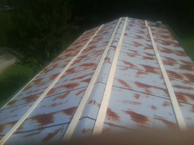 Rusted metal roof panels with new wood purlins before replacement — Storm Damage Roof Repair in Loudon by Roofing Brothers