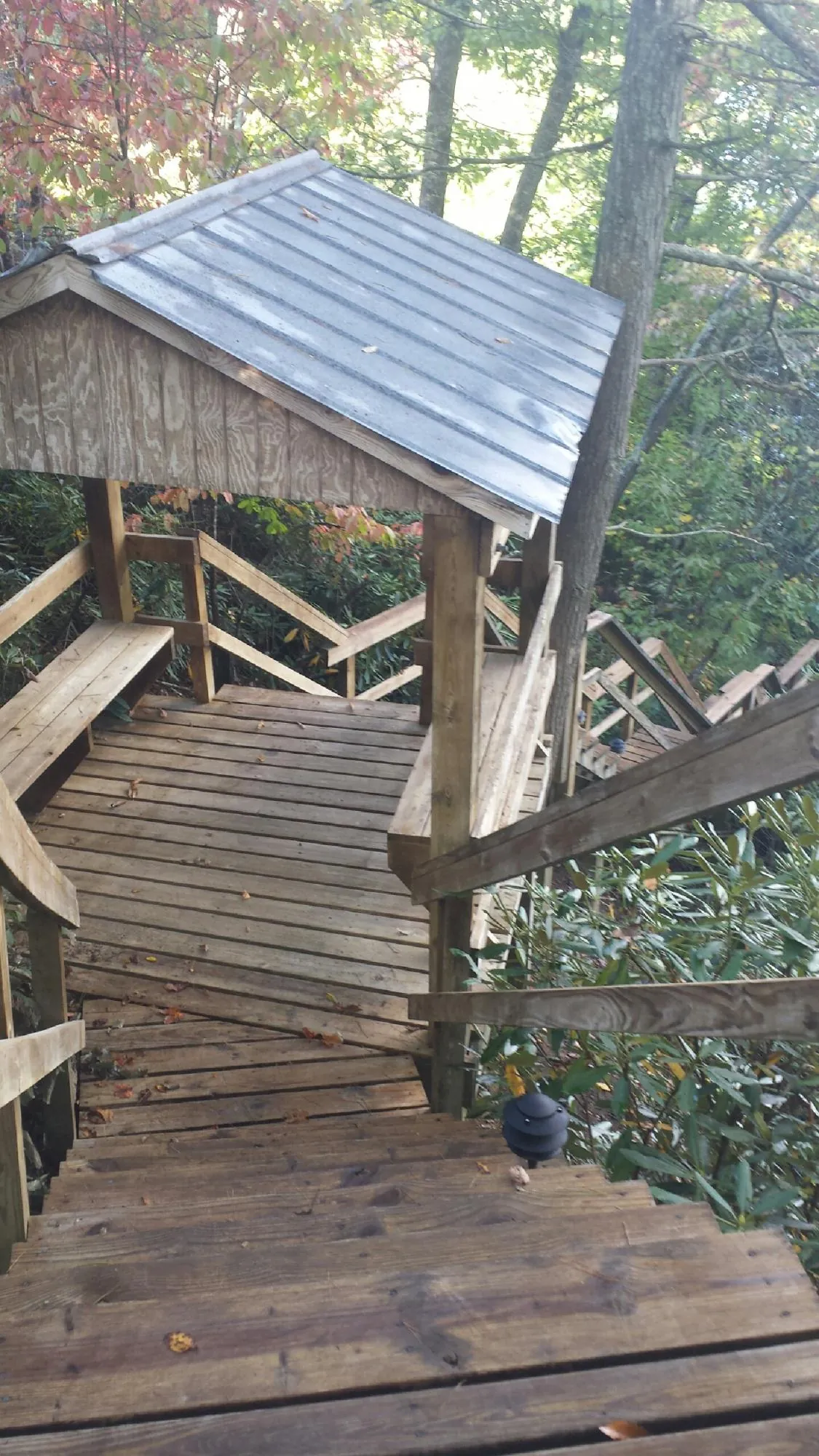 Metal roofed shelter over wooden steps on a wooded walkway — Skylight Repair & Installation work by our crew in Loudon