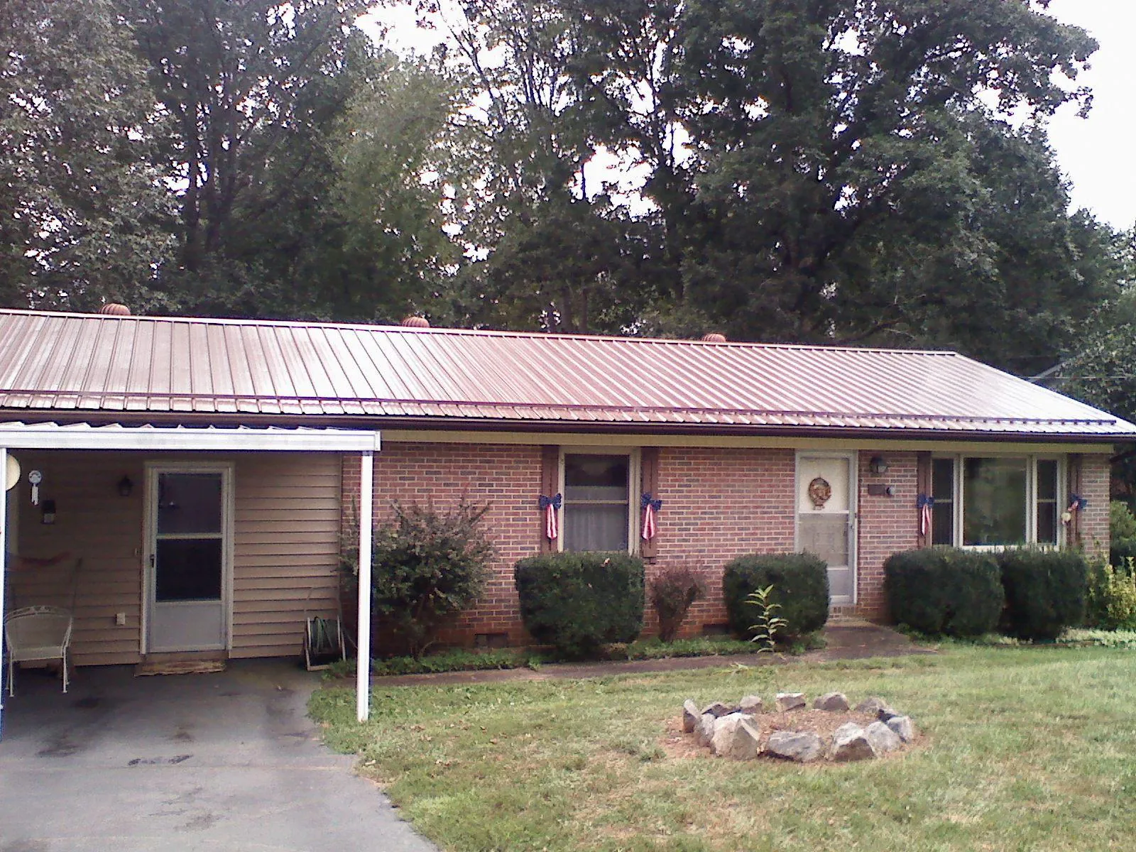 Bronze metal roof and carport on a brick ranch home — Roof Repair work by our crew in Loudon